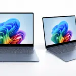 Two slim laptops open on a white surface, displaying a vibrant abstract wallpaper on their screens.