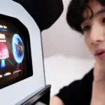 Person closely examining a futuristic touchscreen dashboard with glowing blue circular gauges.
