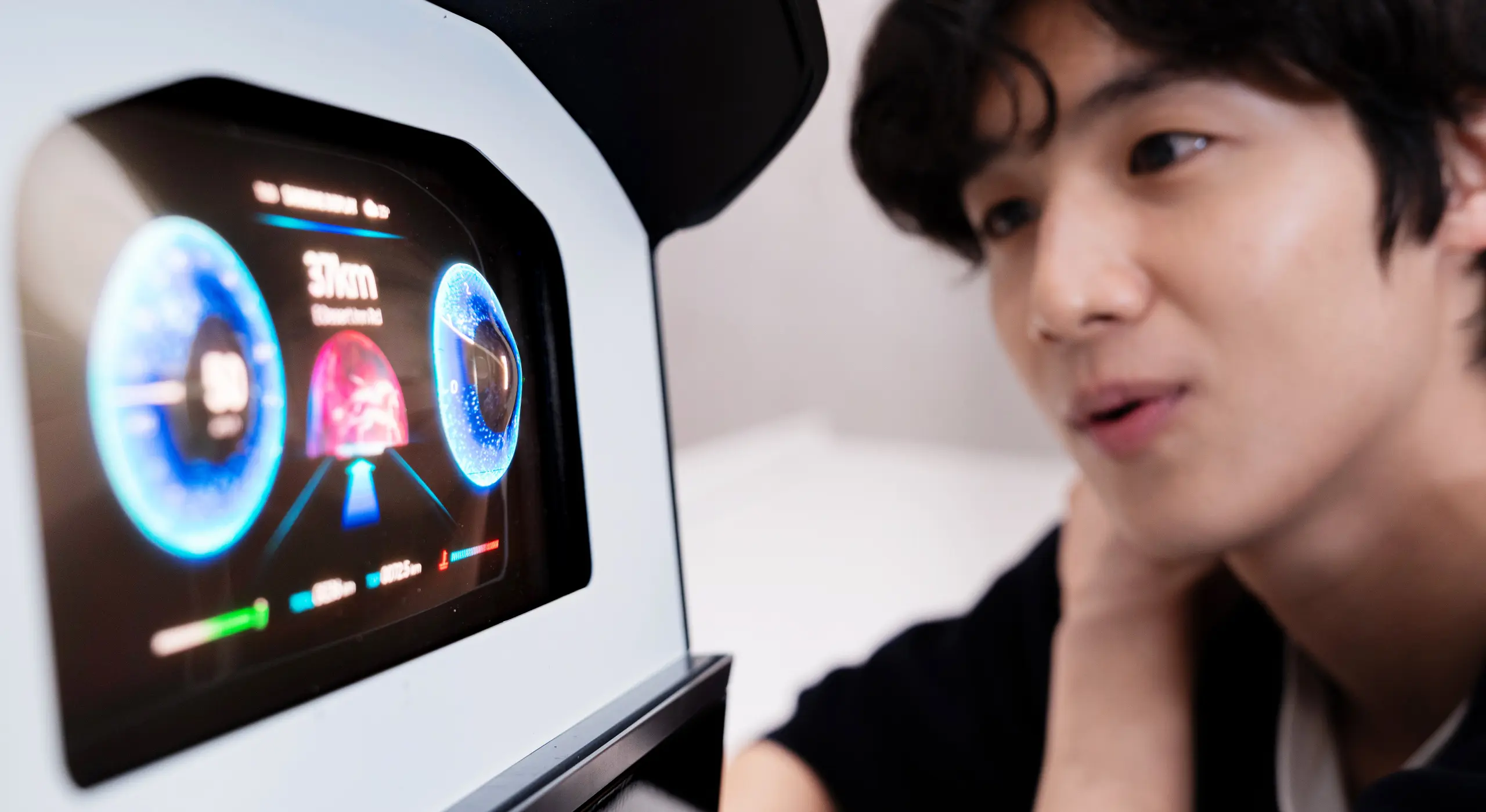 Person closely examining a futuristic touchscreen dashboard with glowing blue circular gauges.