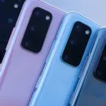 Back view of multiple smartphones in pink and blue finishes, showing large rectangular camera bumps and lenses grouped together in a diagonal row.